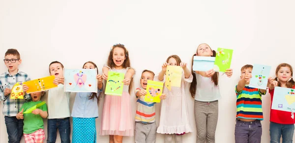 Niños de pie en una fila y mantener tarjetas de felicitación auto-maded, concepto de bricolaje — Foto de Stock