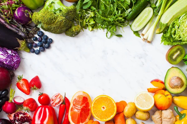 Regenbogenfarbenes Obst und Gemüse auf einem weißen Tisch — Stockfoto