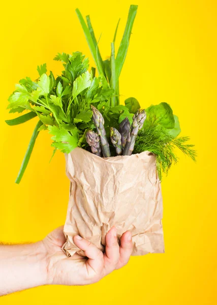 Szparagi i zielone do sałatek w papierowej torbie w ręku — Zdjęcie stockowe