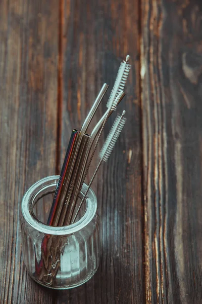 Pailles métalliques réutilisables dans un bocal en verre sur une table en bois — Photo