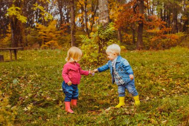 Sonbahar parkında sevimli çocuklar doğa üzerinde oyun