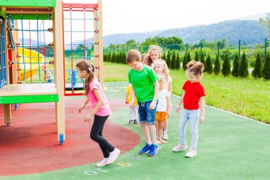 Renkli oyun alanında Hopscotch oyunu oynayan çocuklar