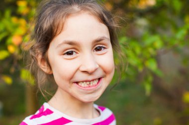 Küçük kız yeni dişini göstererek gülümsüyor