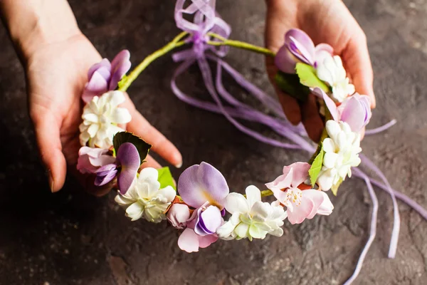 महिलाओं के हाथ स्प्रिंट फूलों के साथ फोम मुकुट पकड़ते हैं — स्टॉक फ़ोटो, इमेज