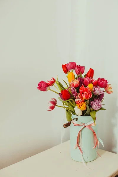 Vícebarevné tulipány v kovové váze na bílém pozadí — Stock fotografie