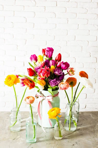 Buquê feito de tulipas entre ranúnculos em garrafas — Fotografia de Stock