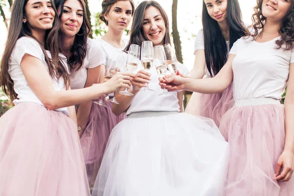 Girlfriends in same clothes cheering up with champagne — Stock Photo, Image