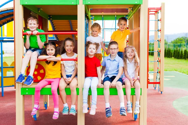 Grupp barn som sitter på en del av lekparken — Stockfoto