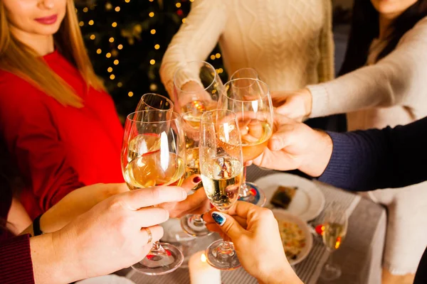 Mãos de jovens batendo copos com champanhe — Fotografia de Stock