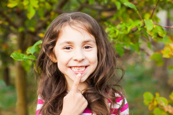 Retrato de menina apontando com o dedo seu novo dente adulto — Fotografia de Stock