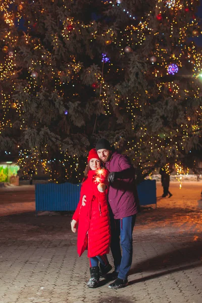 큰 전나무 아래에서 포옹하는 남자와 여자 — 스톡 사진