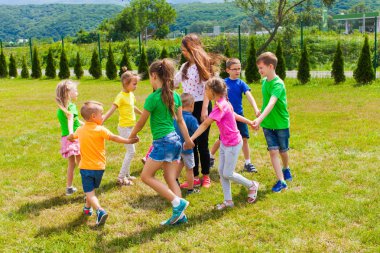 çemberde dans ve şarkı söyleyen çocuklar eğlenin