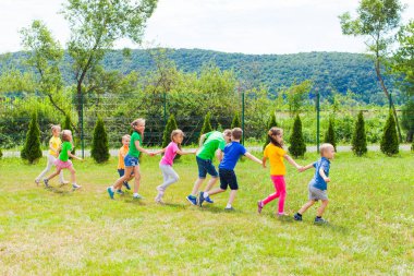 Çimenlerde el ele tutuşan çocuklar
