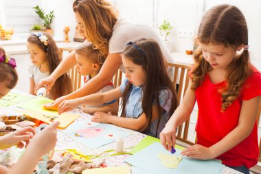 Çocuklar kartpostal yapma konusunda sınıfa katılıyorlar