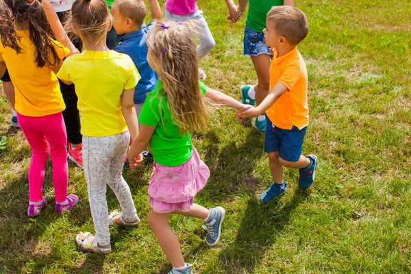 Atividades para crianças de diferentes idades no gramado verde — Fotografia de Stock