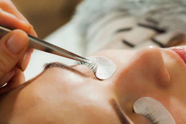 Ojo de mujer de cerca durante la extensión de pestañas — Foto de Stock