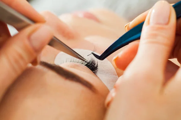 Ojo de mujer de cerca durante la extensión de pestañas — Foto de Stock