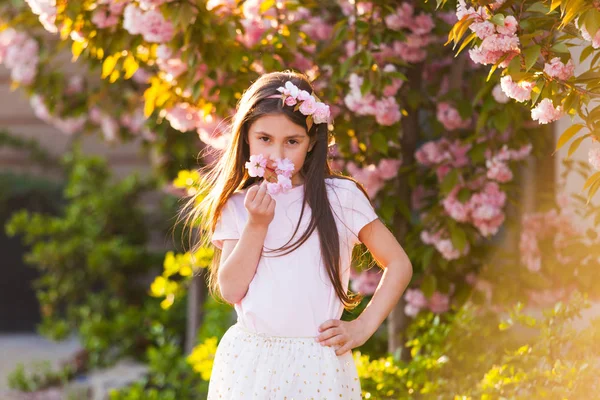 Frühling Porträt, entzückendes kleines Mädchen Spaziergang in Blüte Sakura Baumgarten — Stockfoto
