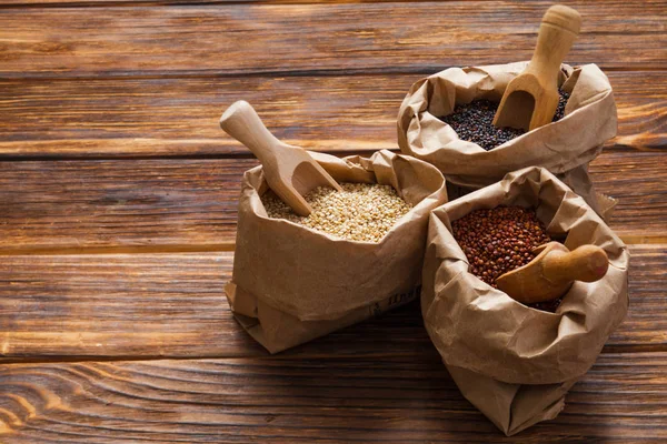 Close up of paper bags with white, red and black quinoa — Stock Photo, Image