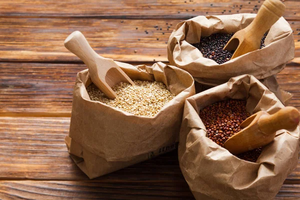 Paper bags with white, red and black quinoa — Stock Photo, Image