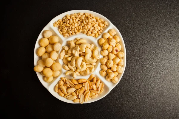 White partitioned dish with variety of nuts — Stock Photo, Image