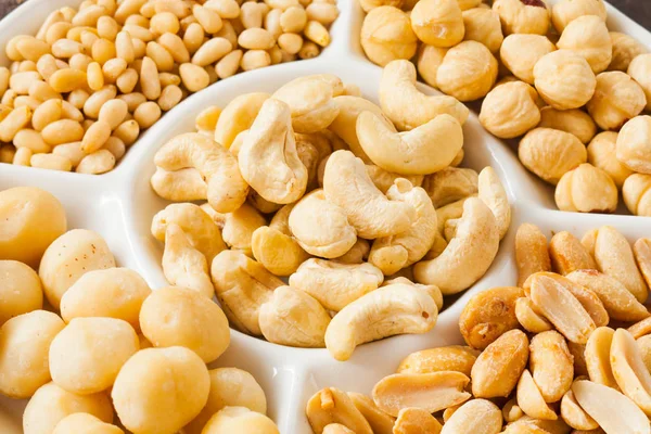 White plate with variety of nuts close up — Stock Photo, Image