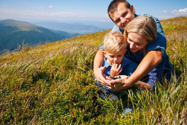 La familia saborea bayas silvestres en colinas de montaña — Foto de Stock