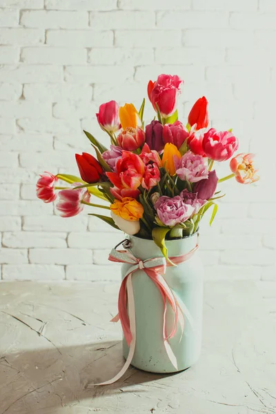 Fresh tulips in metal can on white table — Stock Photo, Image