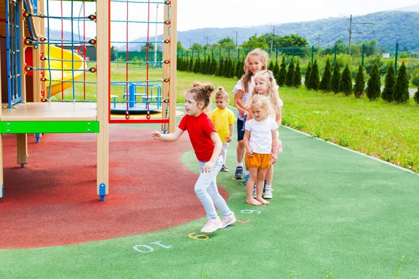 Ragazze che corrono e saltano sul parco giochi all'aperto — Foto Stock