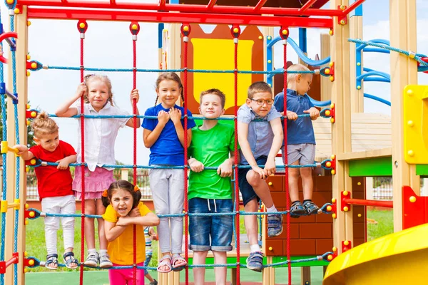 Crianças no parque infantil da escola escalando juntas — Fotografia de Stock