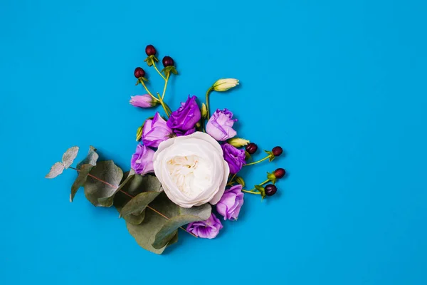 Colocación plana de rosa blanca y eustoma violeta con espacio de copia en azul —  Fotos de Stock