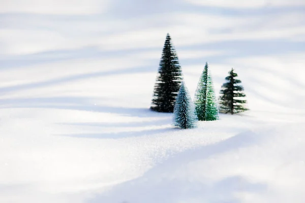 Pequeños árboles de navidad de juguete en la nieve — Foto de Stock