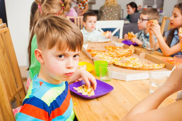 Les enfants mangent de la pizza sur la réunion des enfants — Photo