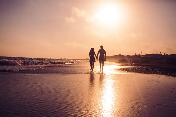 Young romantic couple at the coastline on sunset — Stock Photo, Image