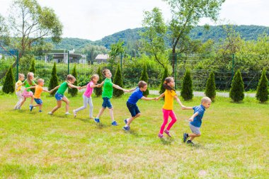 Çocuklar birbirini takip eder ve birlikte koşarlar.