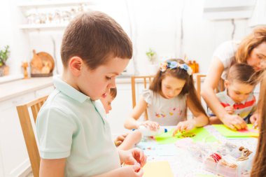 Şirin çocuk, usta sınıfında kartpostalı için bir ayrıntı hazırlıyor.