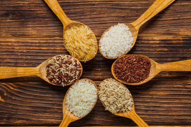 Tahta masada farklı pirinç türleri olan tahta kaşıklar.