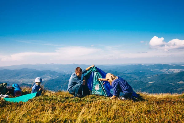 Moeder en vader maken een tent in de bergen — Stockfoto