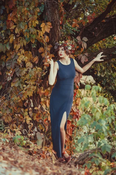 Zmysłowa kobieta z wieńcem nad jesiennym drzewem — Zdjęcie stockowe