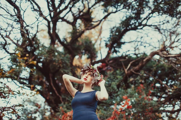 Αισθησιακή γυναίκα με πεσμένο στεφάνι πάνω από το φθινοπωρινό δέντρο — Φωτογραφία Αρχείου