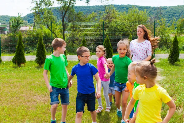 Дети с репетитором едут на детскую площадку в летний лагерь — стоковое фото