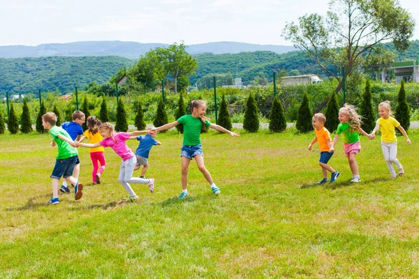 Los niños se divierten y corren al aire libre, siguiendo y riendo — Foto de Stock