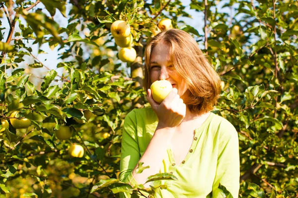 Νεαρή γυναίκα τρώει φρέσκο βιολογικό κίτρινο μήλο — Φωτογραφία Αρχείου