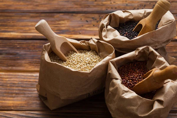 Close up of paper bags with white, red and black quinoa — Stock Photo, Image