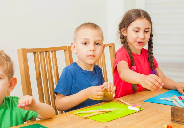 Creatieve kinderen hebben plezier samen met kleurrijke modelleren klei — Stockfoto
