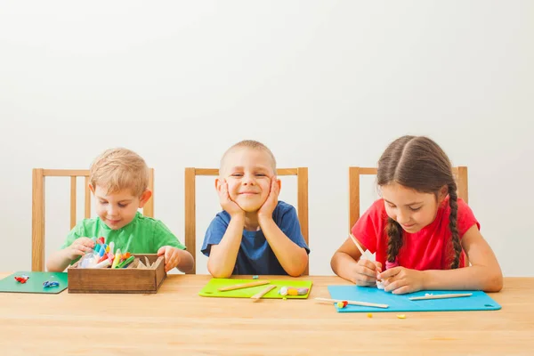 Niños de diferentes edades divirtiéndose juntos con arcilla de modelado colorida — Foto de Stock