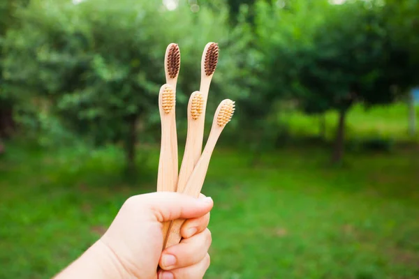 Five bamboo toothbrushes in a hand outdoors — Stock Photo, Image