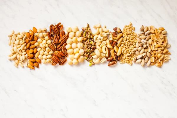 Various nuts collection on the white marble with copy space — Stock Photo, Image