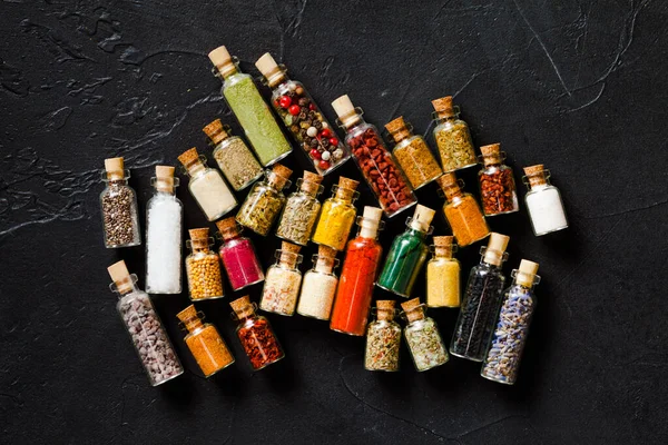 Assorted ground spices in bottles on black background — Stock Photo, Image