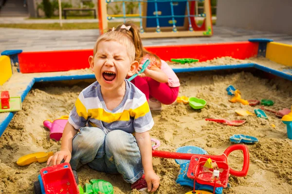Dois garotos sujos brincando na caixa de areia — Fotografia de Stock